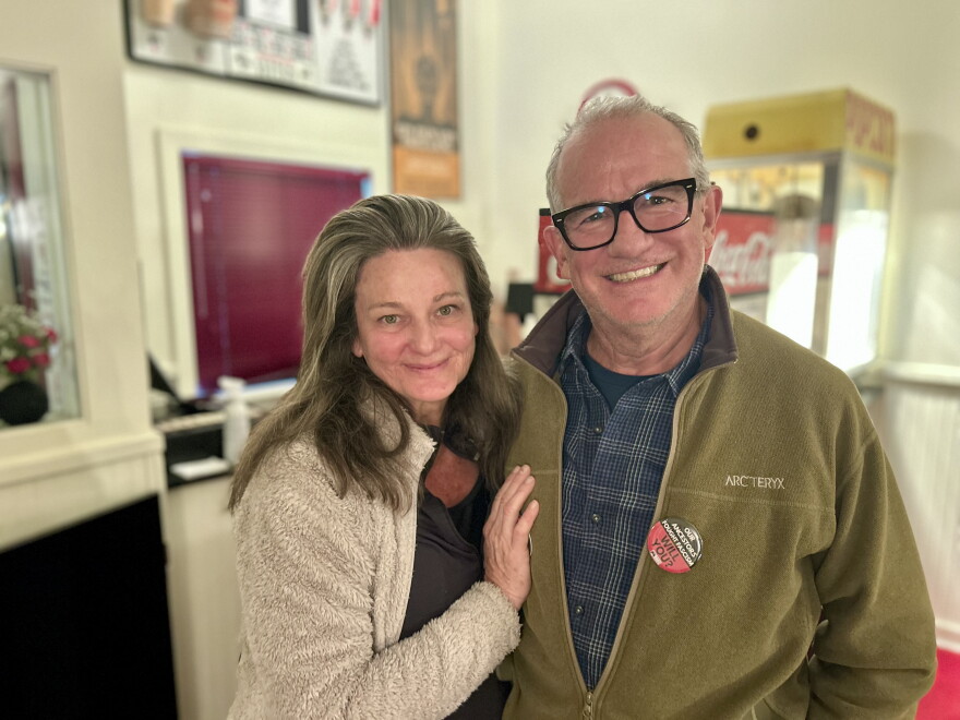 Carbondale residents Helen Copping and Martin Evans pose in front of the concession stand inside the Crystal Theatre after an information session about the statewide ballot measures on Oct. 21, 2026.