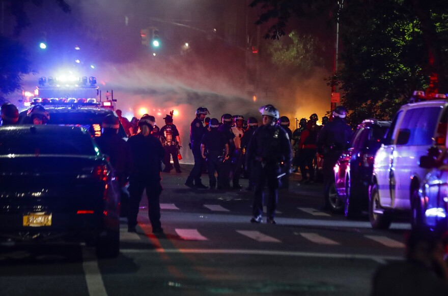 Firefighters spray water on a burning police car after protesters rallied at the Barclays Center on May 29 in the Brooklyn borough of New York.