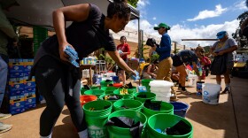 Volunteers sort donated supplies for distribution at Haleiwa Distillery following recent flooding, Tuesday, March 24, 2026, in Waialua, Hawaiʻi. (AP Photo/Mengshin Lin)