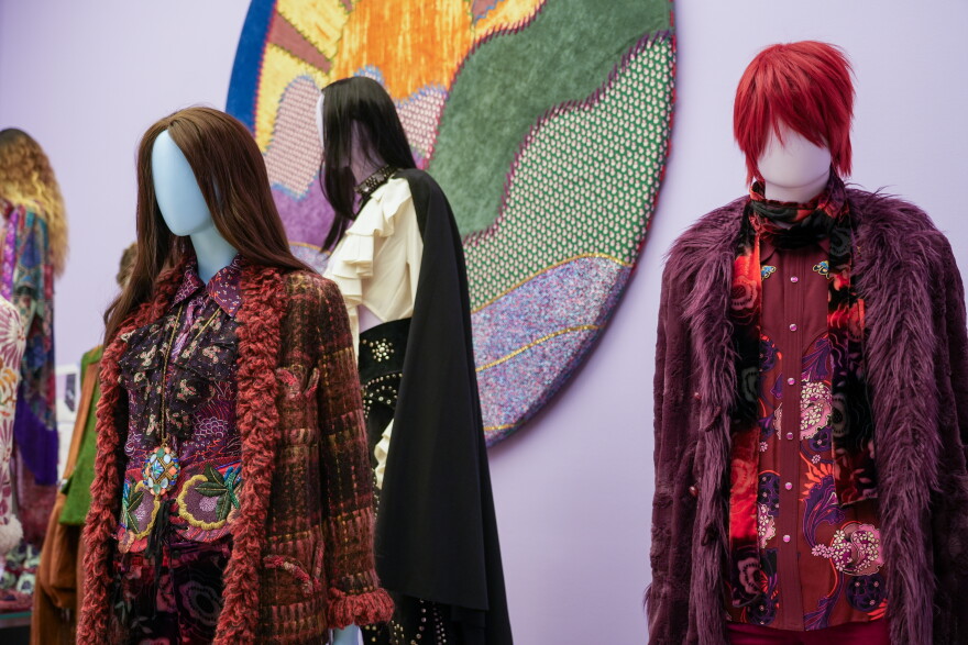 A lavender room staged with two low platforms shows six colorful, eclectic designs by Anna Sui, ranging from a bohemian babydoll dress to fringed styles influenced by American Western wear.