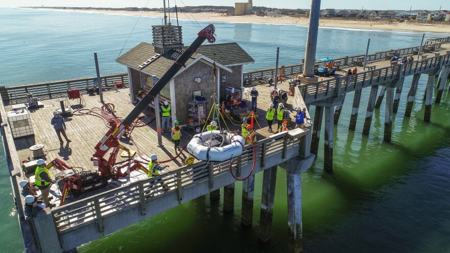 A crew deploys a wave energy device off Jennette's Pier in Nags Head, N.C.