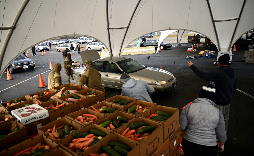 Volunteers load cars and push drivers through the line at Rentschler Field in East Hartford, where Foodshare distributed food to those in need throughout the coronavirus pandemic.