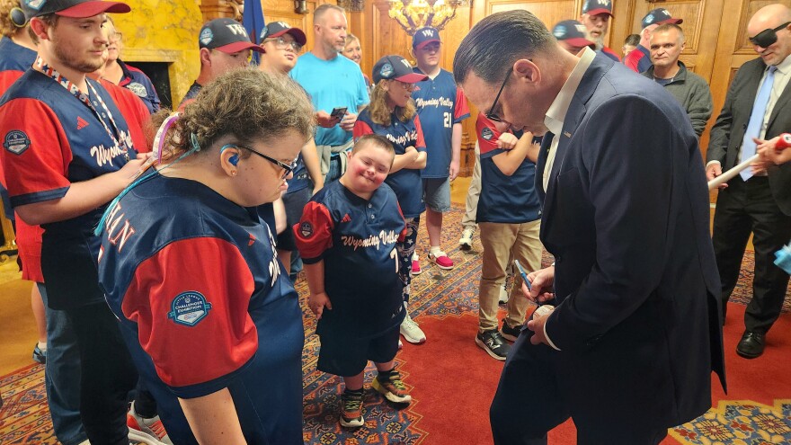 Gov. Josh Shapiro signs a baseball for Wyoming Valley player Mckenna Granahan.