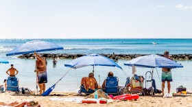 Visitors set up umbrellas at Kūhiō Beach in Waikīkī. (February 25, 2026)