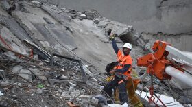 A rescuer and a firefighter search for survivors in a flattened building in Mexico City on Sept. 21, 2017, as the search for survivors continues two days after a strong quake hit Central Mexico. (Yuri Cortez/AFP/Getty Images)
