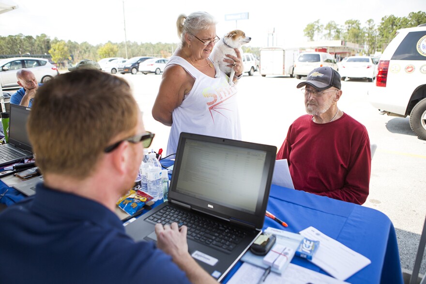 Gerald Kosztur, left, talks with Fay Sadler, center, and Bud Sadler, right, as they arrive at a Veterans Affairs mobile health clinic in Havelock on Thursday, September 20, 2018 following Hurricane Florence.