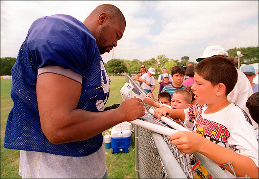 Charles Haley signing a young fan's helmet