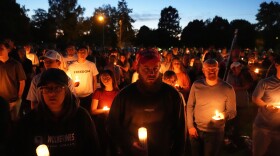 FILE - Carly Jenkins, left, and Alex Thomson, center, pay their respects alongside others during a vigil for Charlie Kirk on Sept. 12, 2025, in Provo, Utah. (AP Photo/Lindsey Wasson, File)
