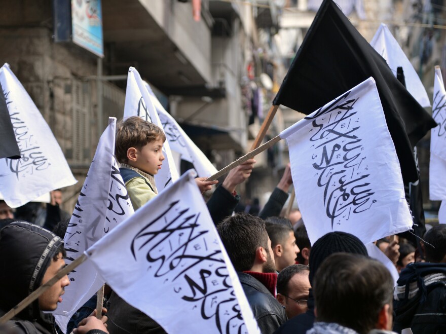 Supporters of the opposition Islamist group Al-Nusra wave their black-and-white flags during an anti-government demonstration earlier this month in the northern Syrian city of Aleppo.