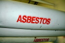 Pipes with white insulation wrap are labeled "asbestos" in red. 