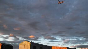 A plane flies over the town after taking off from the dirt runway in Kivalina, Alaska. Supplies needed for the town are brought in either by barge or plane since there are no roads leading to the other towns from the village.