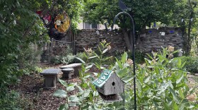 Front garden entrance with bird house, mosaic tiled benches, and bicycle glass wheels.