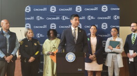 Aftab Pureval stands at a podium in front of six people 