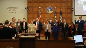 Group of people with hands raised for swearing in ceremony