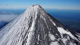 David Fee / Alaska Volcano Observatory Shishaldin Volcano’s base diameter is about 10 miles (16 km) and it has a smaller summit crater at the peak.