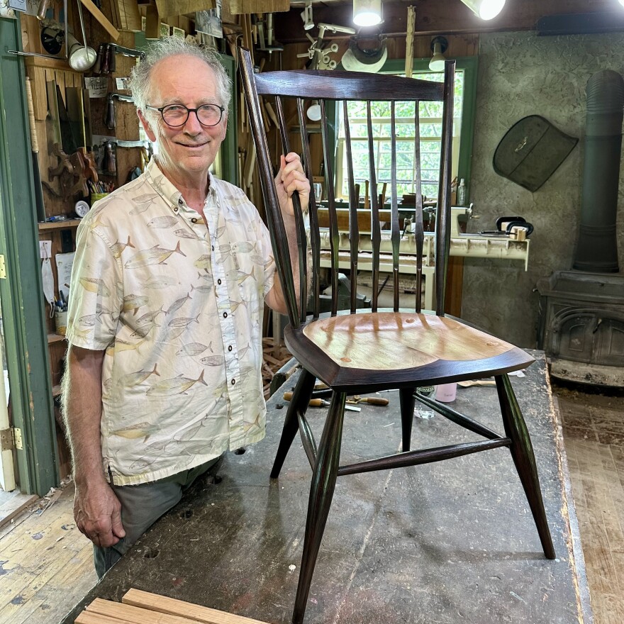 Curtis Buchanan stands next to a Windsor chair he made.