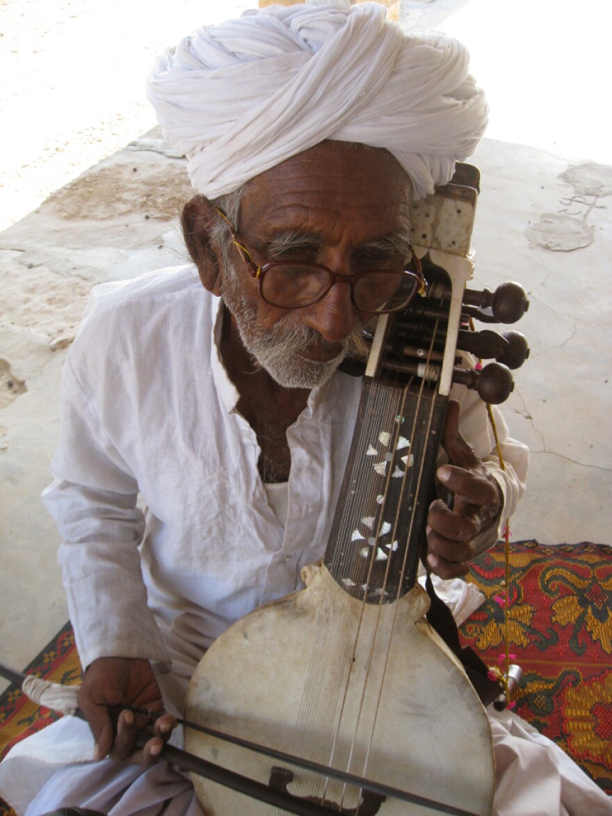 Sakar Khan with his kamancha in his home in Hamira, Jaisalmer, Rajasthan. He's passed his favorite kamancha — the one he got from his father — to his son, Darra. But this one plays just fine, if he's the guy playing it.