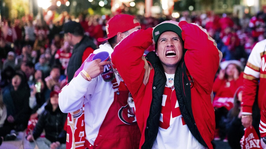 A San Francisco 49ers fan reacts while watching a telecast of NFL football's Super Bowl 58 on a screen outside the Chase Center in San Francisco on Sunday, Feb. 11, 2024.