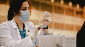 A vaccinator administers a dose of a COVID-19 vaccine at the Ernest N. Morial Convention Center. March 4, 2021.