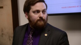 a portrait of a man with a screen behind him