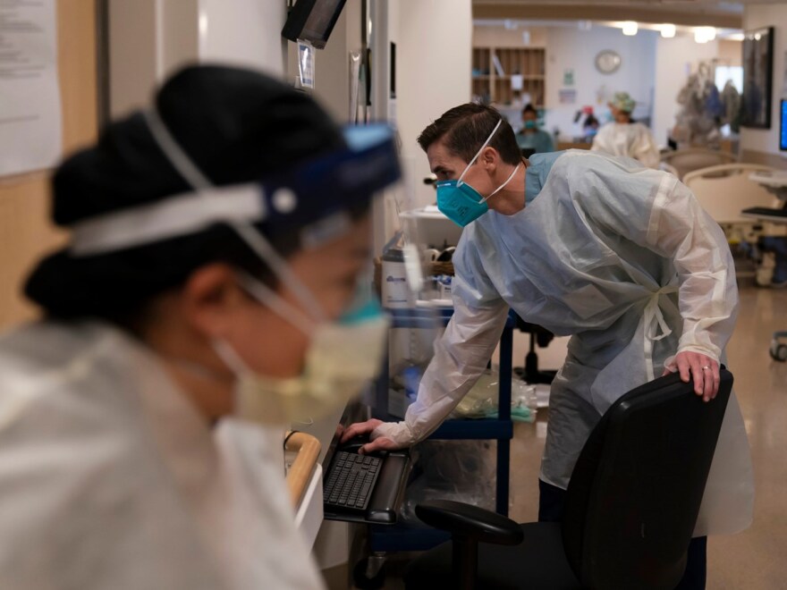 Registered Nurse Richard Moses looks at his computer while working in a COVID-19 unit at Providence Holy Cross Medical Center in the Mission Hills section of Los Angeles, Thursday, Nov. 19, 2020.