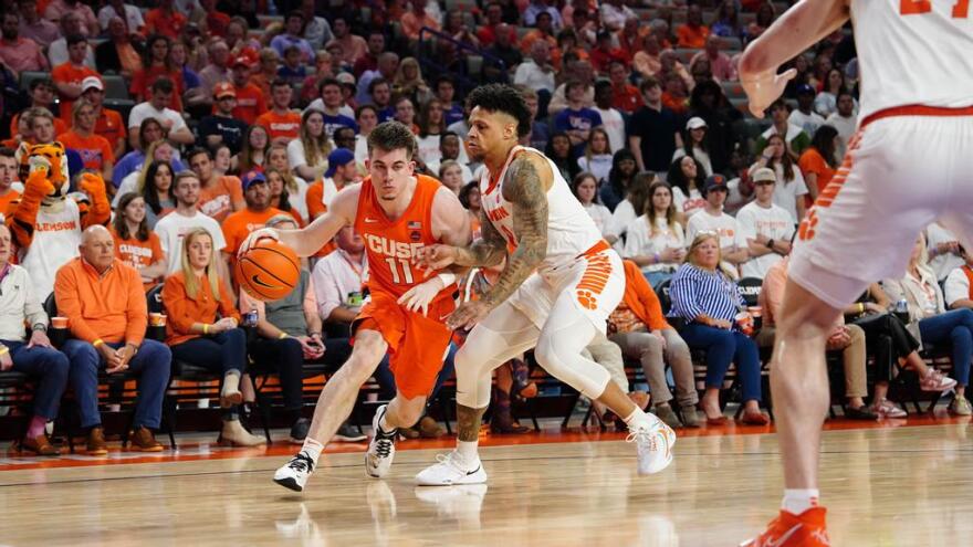 Joe Girard (orange, 11) drives against Brevin Galloway of Clemson.