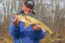 A man holds a walleye on a Minnesota lake measuring 28 inches
