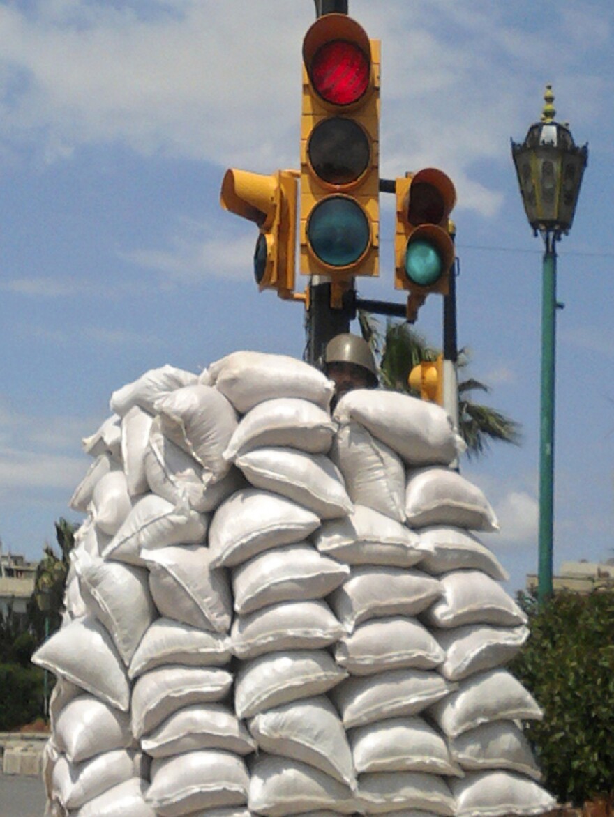 A Syrian soldier hid behind a sand bag barricade in the central city of Homs on Friday.
