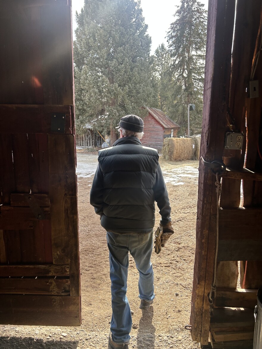 Jay Fetcher walks through a barn door on his ranch in Routt County, Colorado.