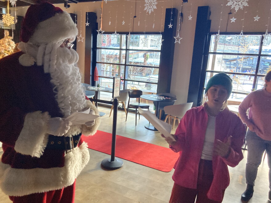 Erin gestures to Santa and other volunteers while preparing everyone for the event. 