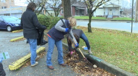 White River Alliance staff cleaning out a storm drain in the organization's office parking lot.