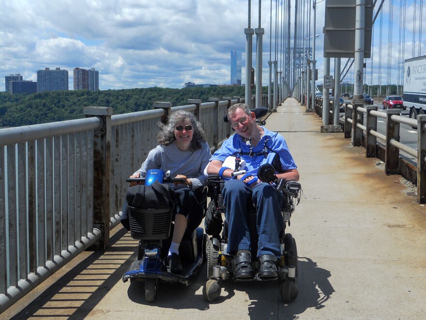 Dr. Lisa Iezzoni and her friend, Michael Ogg, crossing the George Washington Bridge, over New York's Hudson River, in their motorized wheelchairs, after Ogg survived a cancer diagnosis. Iezzoni has written about another doctor who declined to do a physical exam of Ogg. Merely lifting his shirt would have revealed evidence of cancer, she says.