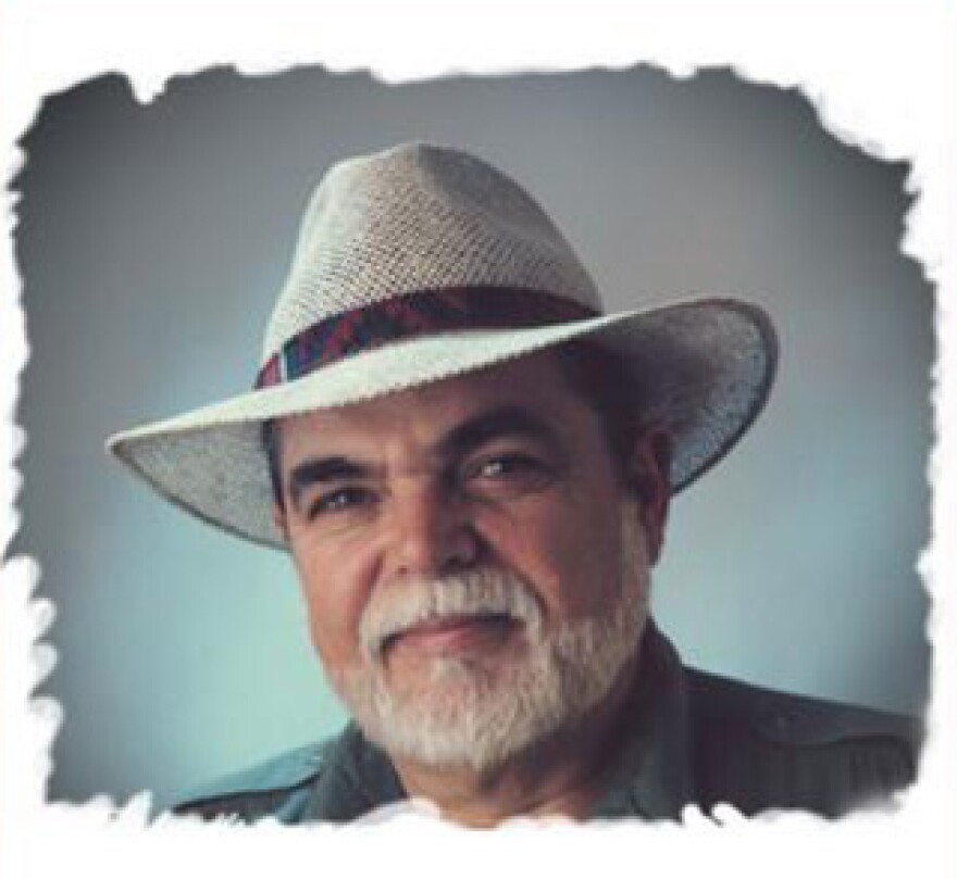 A older man is wearing a suit and a straw hat