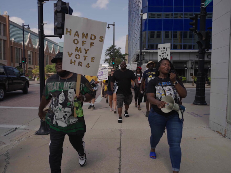A group of union members is walking down the street to protest for their vote.