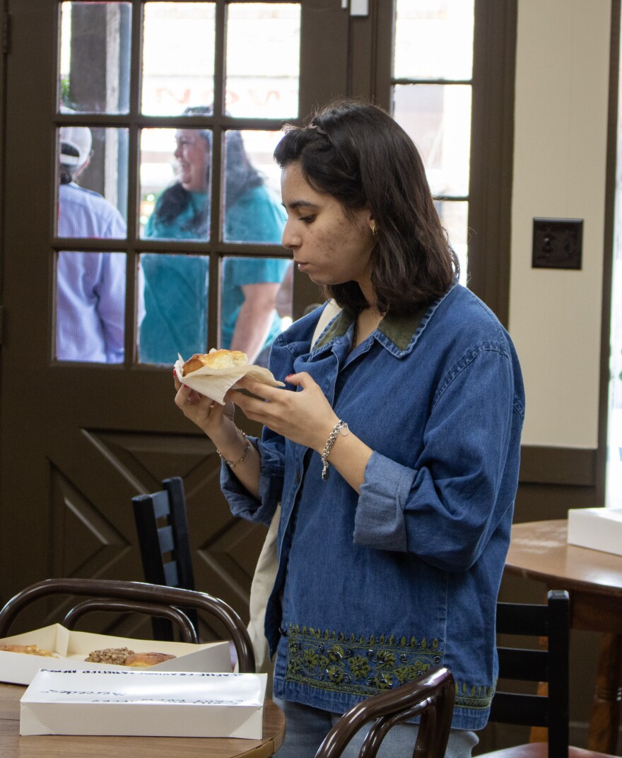 Mercedez Concepcion tries her first Village Bakery kolache during the bakery's reopening on Saturday, May 23, 2026. Concepcion said she's waited almost eight years to try a kolache from Village Bakery.