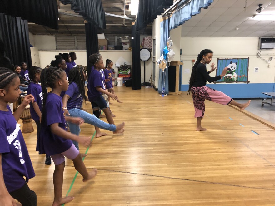 Teacher Asha Darbeau, right, directs her dance class in a warmup.