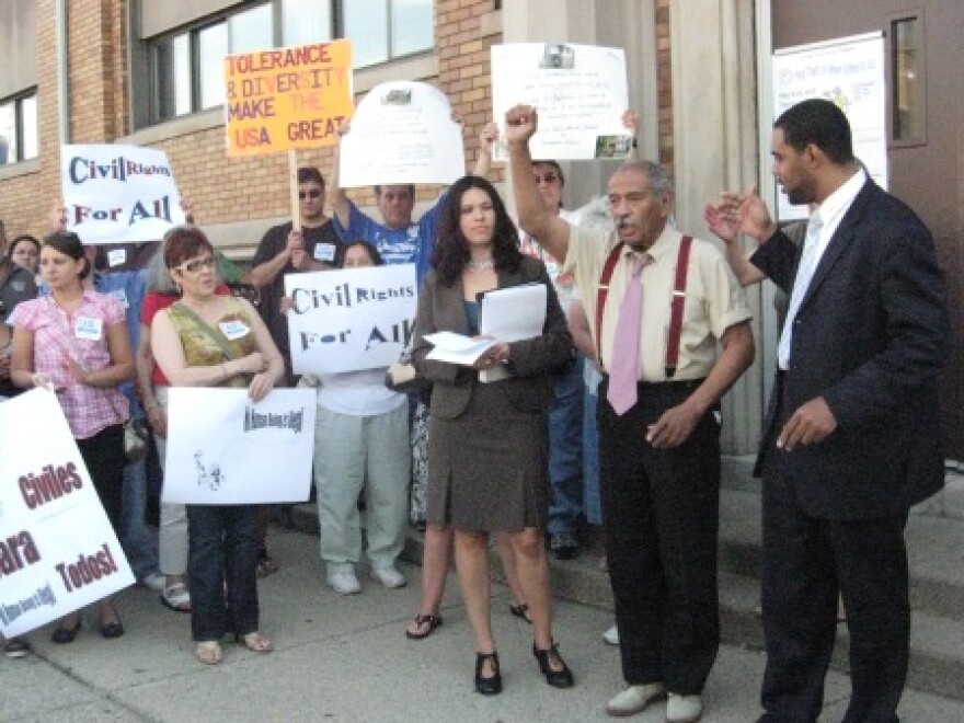 U.S. Representative John Conyers, second from right, rallies community members ahead of an immigration forum.