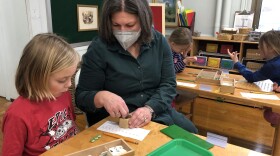 Maryland Avenue Montessori teacher Tanja Price works on a math exercise with a student. This photo was taken on April 19, when masks were optional in MPS.