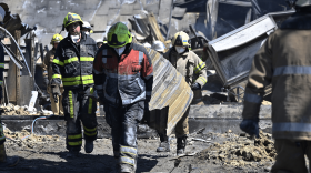 Workers are seen clearing the rubbles of the Amstor mall, the day after it was hit by a Russian missile strike according to Ukrainian authorities in Kremenchuk. (Genya Savilov/Getty Images)