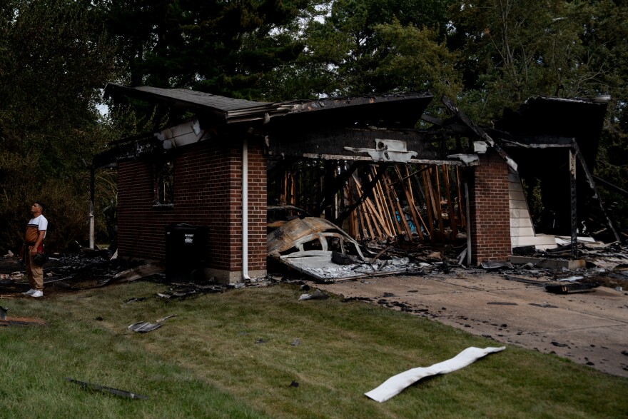 Workers assess damage near homes destroyed in a massive explosion of unknown cause on Monday, Aug. 25, 2025, near Black Jack. The blast destroyed at least five homes and damaged more than 20 others, leaving the neighborhood washed in debris.