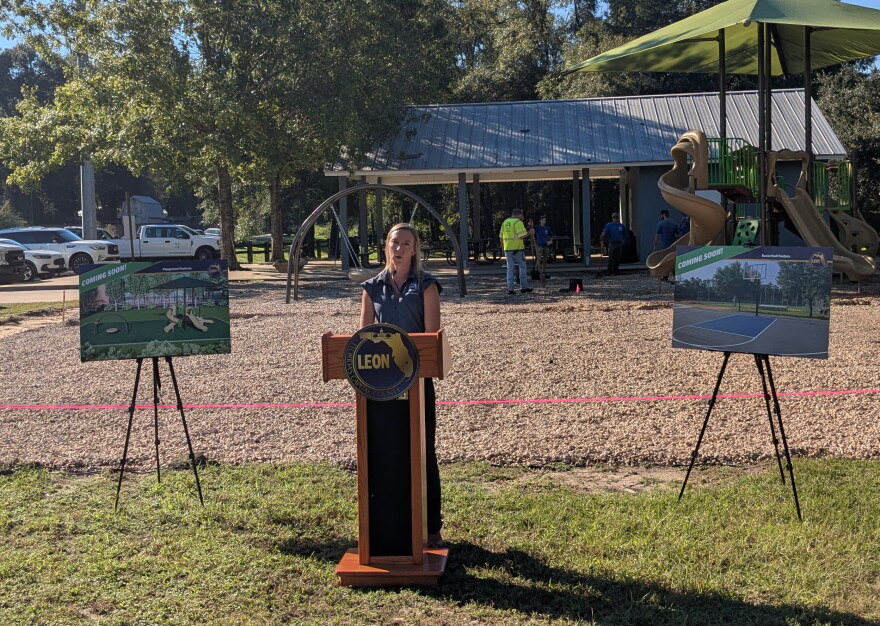 Leon County Parks and Recreation Director Amanda Heidecker makes remarks in front of the half-court basketball space now under construction at the Tower Road Park.