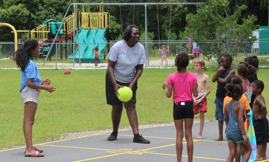 Waldo Summer Camp director Lisa Hill plays a game of four square with campers in front of the Waldo Community Center playground Wednesday, July 18, 2018. (John Peterson/WUFT News)