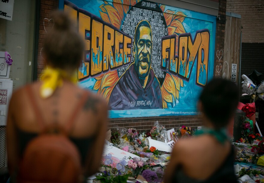 People defy the curfew to pay their respects at the makeshift memorial and mural outside Cup Foods where George Floyd was killed on May 31 in Minneapolis.