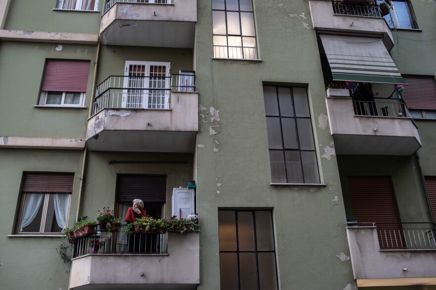 A woman looks out from her balcony in the Prenestina neighborhood of Rome.