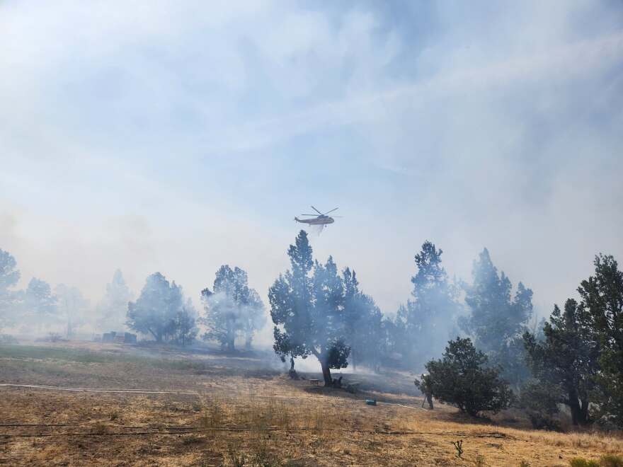 A helicopter drops water on the Oak Fire west of Redmond on July 19, 2026.