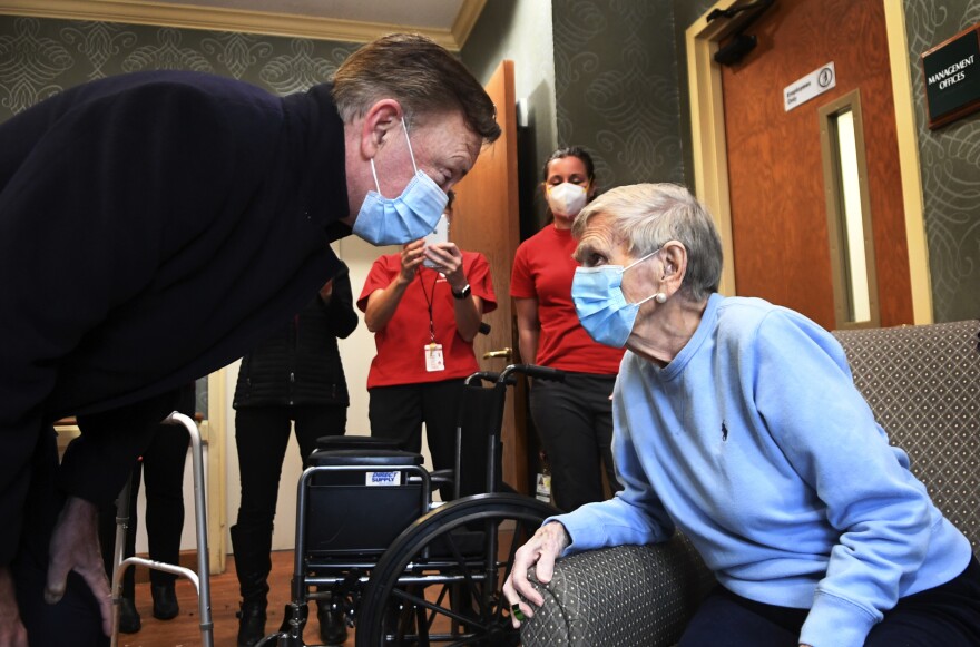 Gov. Ned Lamont, left, talks with Jeanne Peters, 95, during a visit to The Reservoir nursing home after she was given the first COVID-19 vaccination, Friday, Dec. 18, 2020, in West Hartford, Conn.