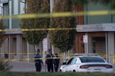 Officers behind yellow caution tape outside a school.