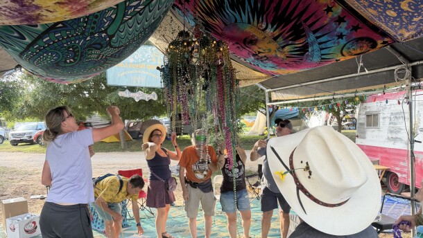 Kerdi Gras (like Mardi Gras, but in Kerrville). They're throwing beads into the deer-horn chandelier.