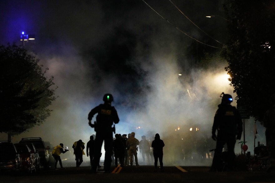 FILE - Law enforcement officers stand after deploying tear gas outside a U.S. Immigration and Customs Enforcement facility during a protest on Oct. 4, 2025, in Portland, Ore. (AP Photo/Jenny Kane, File)