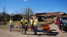 Aid workers and ordinary citizens work together in the aftermath of the tornado that tore through Muhlenberg County last February.